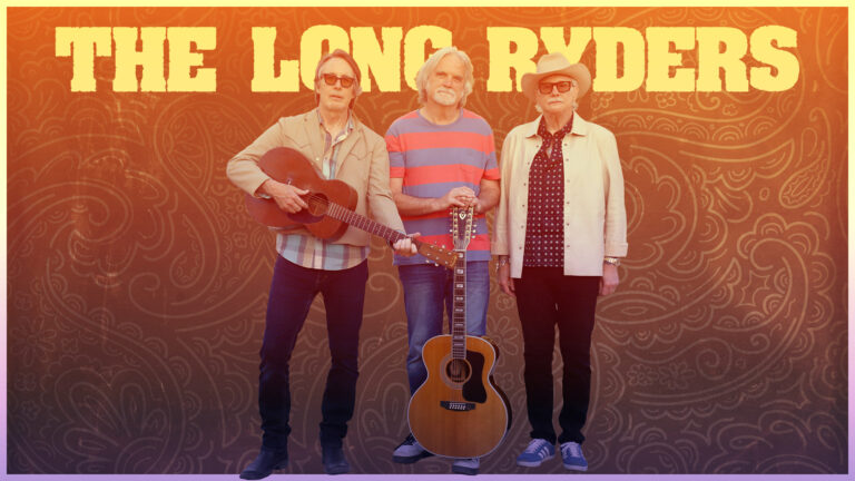 Three people standing with two acoustic guitars in front of a patterned background, text reads “THE LONG RYDERS.