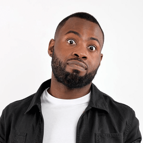 A headshot of Darren Harriott looking at the camera, wearing a white T-shirt and a dark shirt that's unbuttoned.
